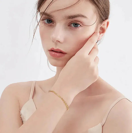 woman wearing gold byzantine bracelet with elegant winter outfit