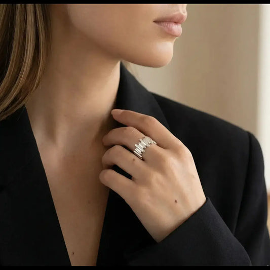 A bold Sterling Silver Irregular Wide Ring on a woman's finger, styled with a minimalist black blazer for a sophisticated, sculptural look.