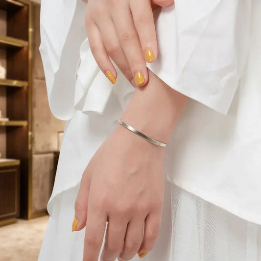 Elegant 925 silver herringbone chain jewellery on a white marble table with a high-end aesthetic.