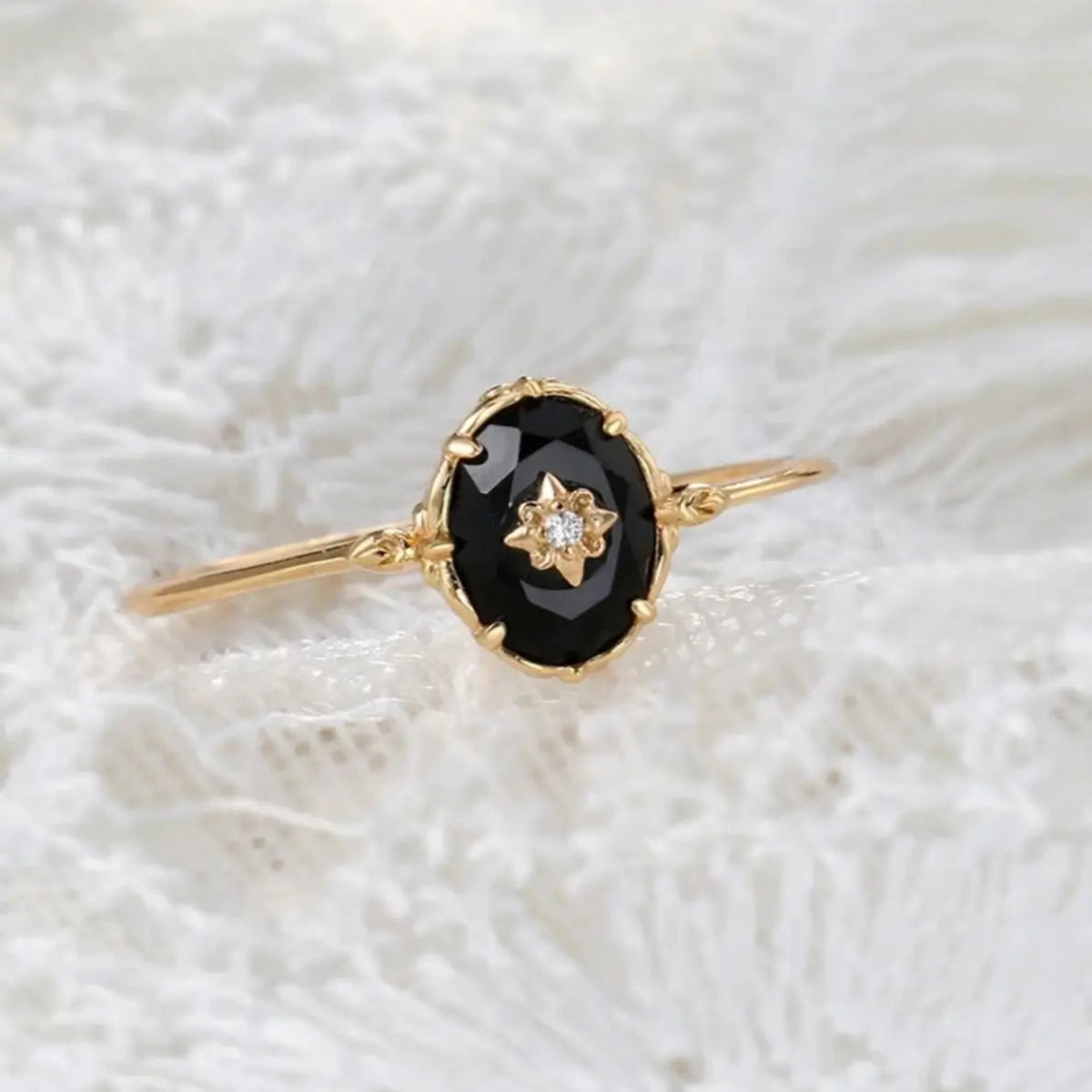 oval black stone ring with delicate gold detailing