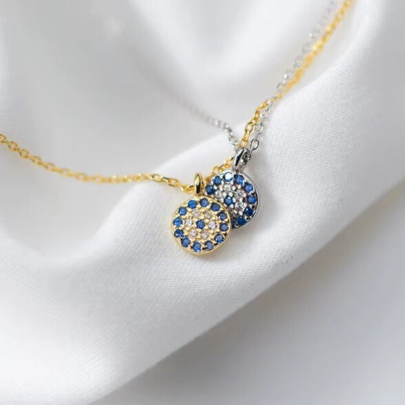 Small CZ evil eye charm shown next to ruler for size guide