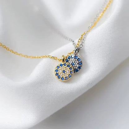Small CZ evil eye charm shown next to ruler for size guide