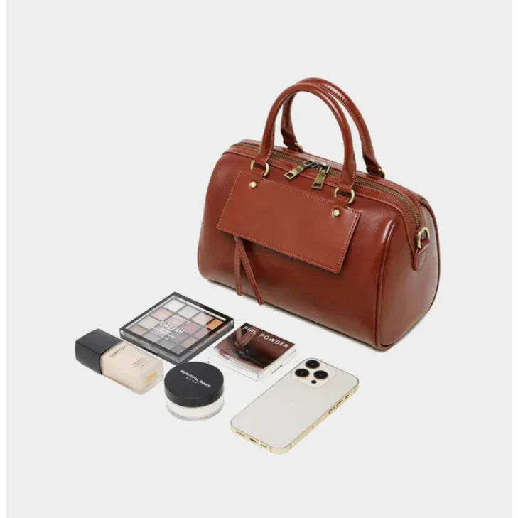 compact brown wine or black leather handbag