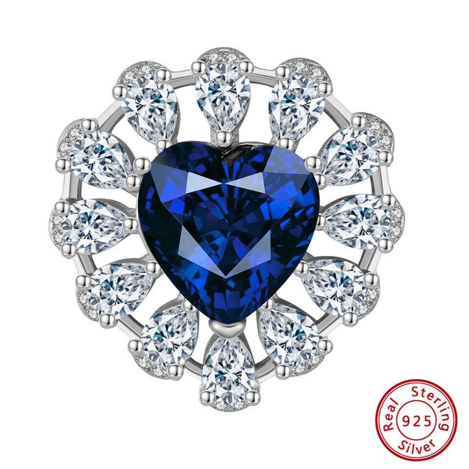 Sapphire heart and CZ halo pendant lying on jewellery tray
