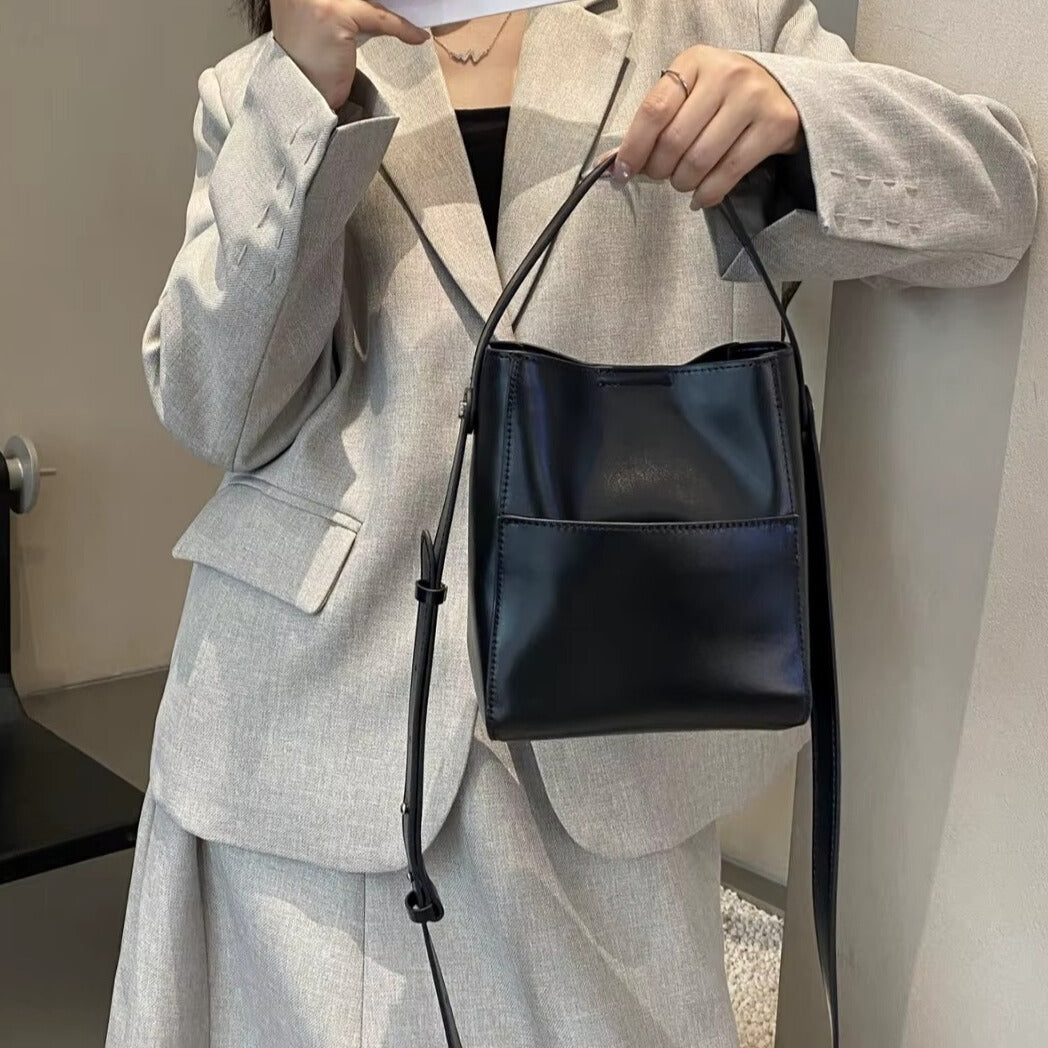 close up of adjustable strap on elegantia alira black leather bucket shoulder bag