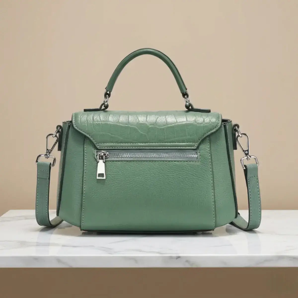 Back view of green leather satchel showing adjustable strap.