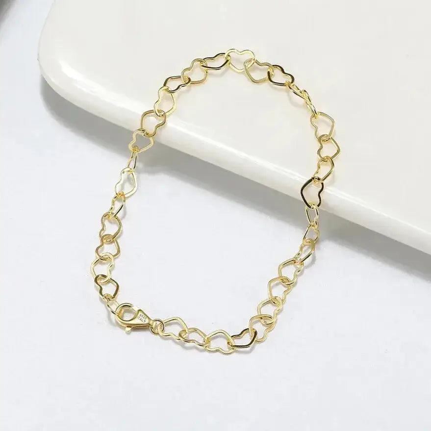 close-up of polished gold heart links with lobster clasp