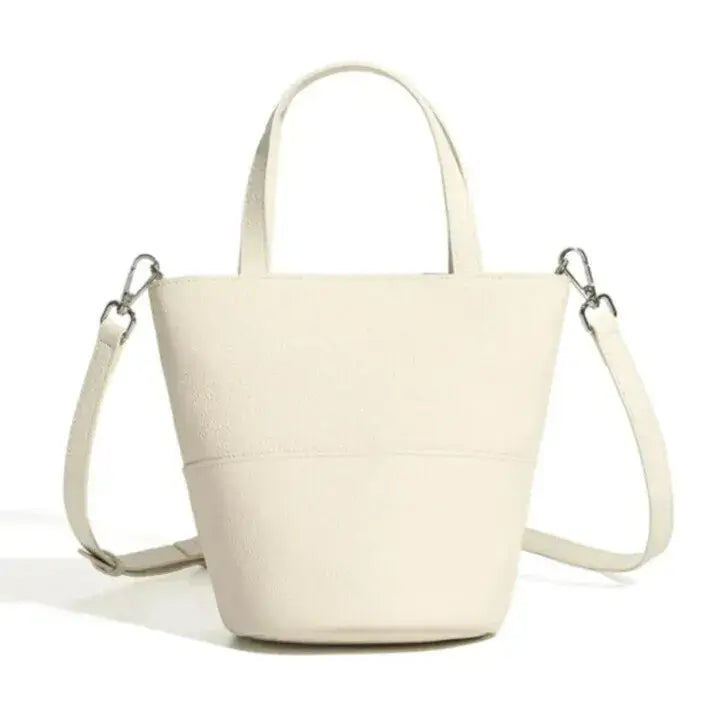 beige leather bucket bag worn as shoulder bag