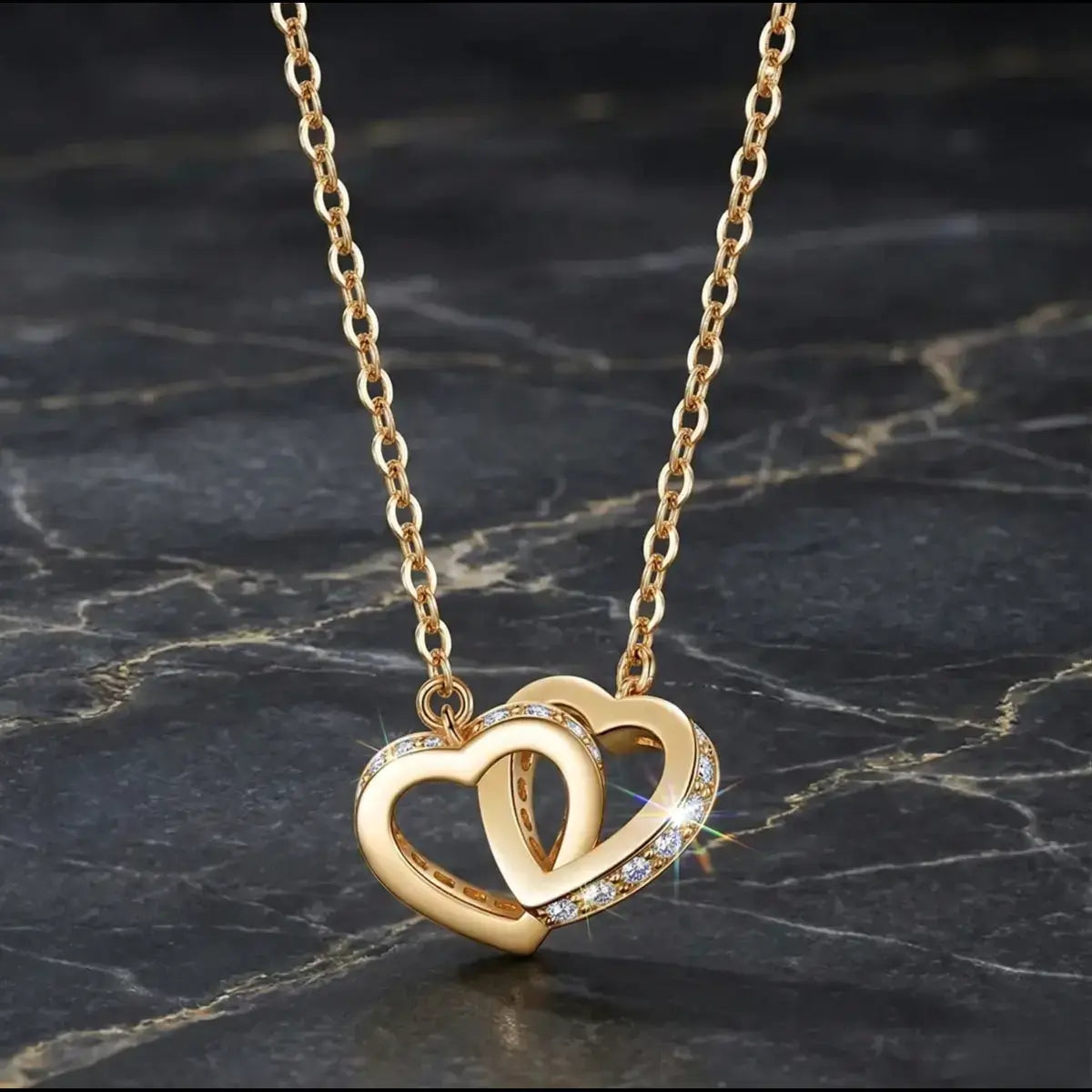 Macro shot of twin interlocked hearts in yellow gold, showcasing the intricate pavé jewellery craft with moissanite stones on the side.