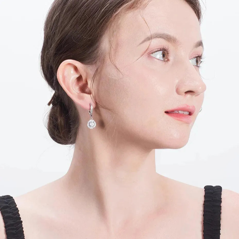 Silver drop earrings on model ear