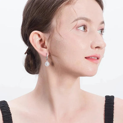Silver drop earrings on model ear