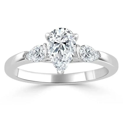 Close-up of a teardrop moissanite centre stone 1ct and shimmering cubic zirconia side stones in a polished sterling silver setting.