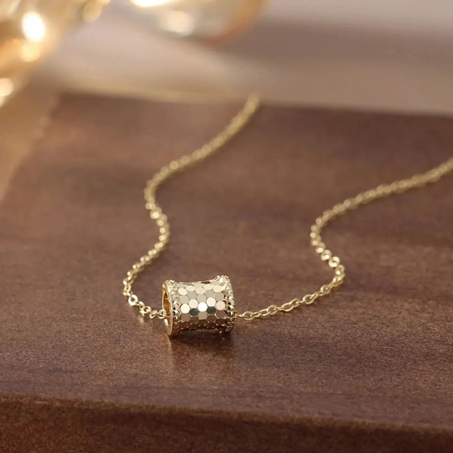 gold tone vintage pendant necklace on marble surface flat lay