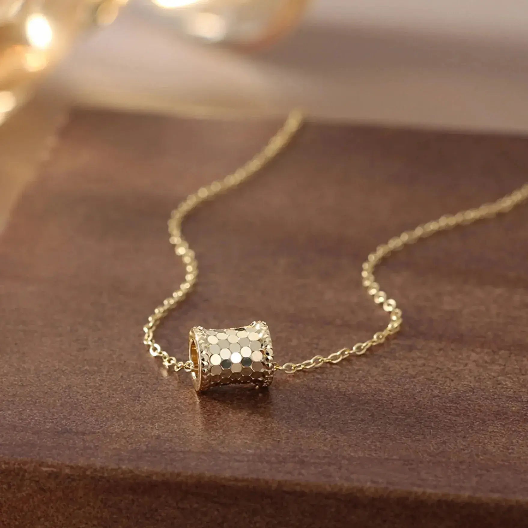 gold tone vintage pendant necklace on marble surface flat lay