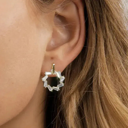 geometric gold dangle earrings on ear