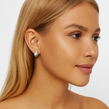 silver smooth teardrop earrings on model ear