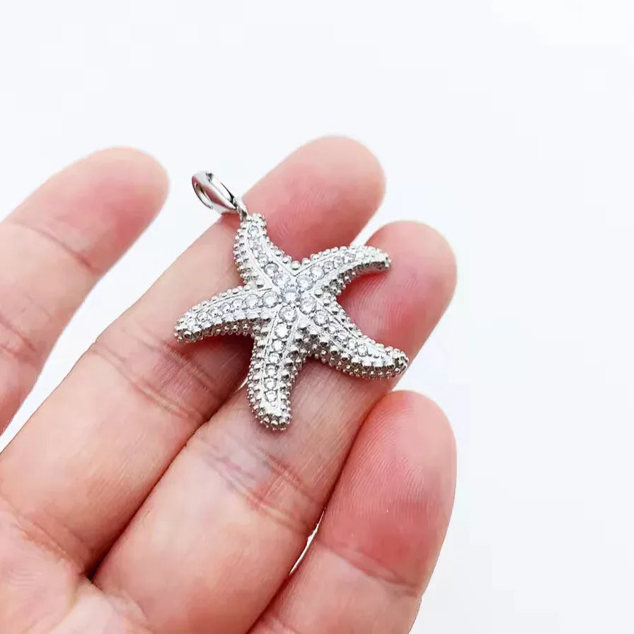 polished silver starfish pendant flat lay
