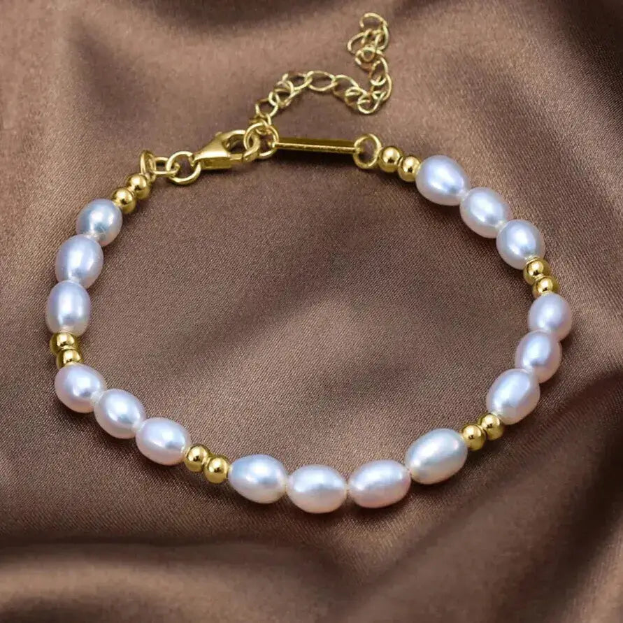 minimalist pearl and gold bracelet against neutral background